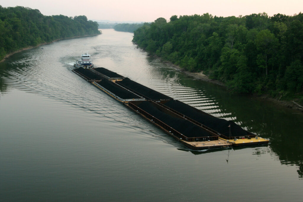 Large coal barge heading downriver on the Cumberland River Tennessee. Barges and boats run better with BargeOps.