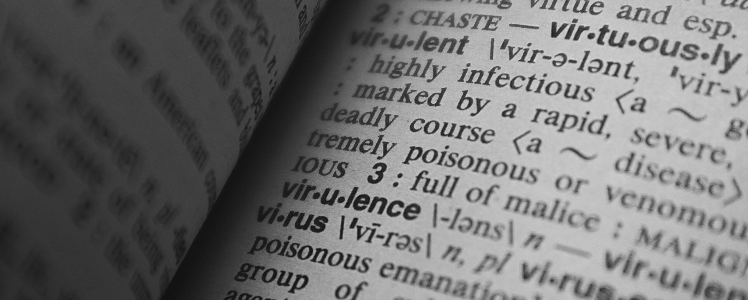Black and white close-up of a dictionary page showing the definition of 'virus.'